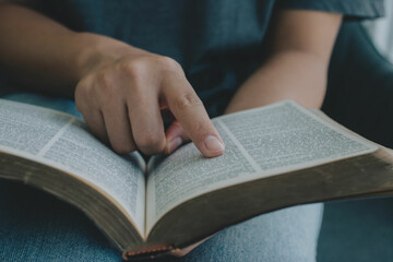 Fototapeta premium Close-up of woman hands reading the Bible. Christian background. freedom. Concept for faith, spirituality and religion