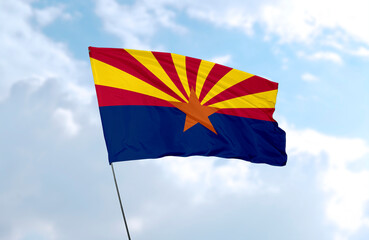 Flag of Arizona in front of blue sky, realistic 3D rendering