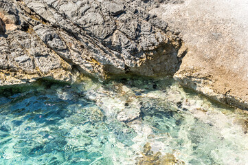Stone rock washed by sea water. Close up. Vacation background.