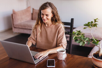 Cheerful woman using silver laptop
