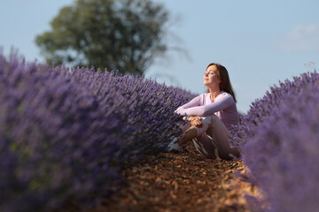 Woman resting sitting in a lavender field - Powered by Adobe