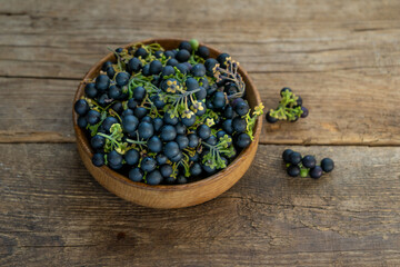 Black nightshade berries in a plate on table close-up. Nightshade in cooking. Healthy food. Harvest for baking