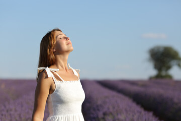 Fototapeta na wymiar Woman in white breathing fresh air in lavender field