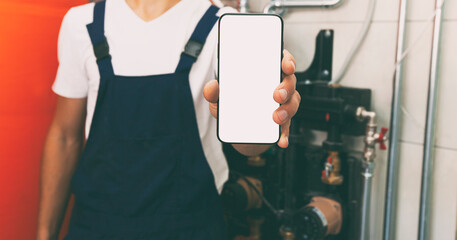 White blank screen on phone in plumber's hand in protection gloves. mockup for house repair or building or installing heating system