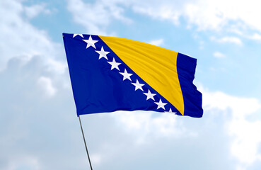 Flag of Bosnia and Herzegovina, realistic 3d rendering in front of blue sky