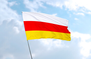 Flag of South Ossetia, realistic 3d rendering in front of blue sky