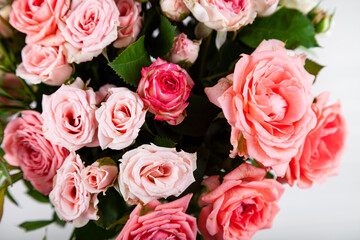 Bouquet of pink roses on a light wooden background.
