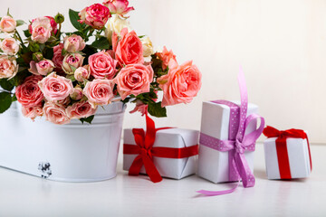 Bouquet of pink roses and boxes with gifts