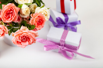 Bouquet of pink roses and boxes with gifts