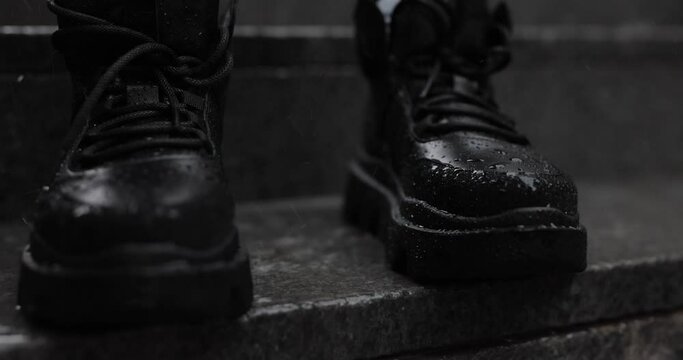 Slow motion rain on the black boots