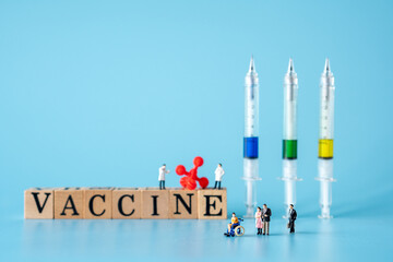 miniature of doctor and patient wear a mask to prevent virus..red virus with Wooden cubes with words ''vaccine
