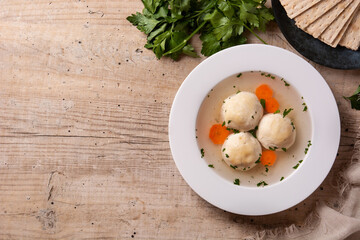 Traditional Jewish matzah ball soup on wooden table. Top view. Copy space