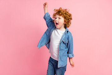 Photo of crazy positive foxy small boy dance raise arm open mouth wear denim jacket isolated pink color background
