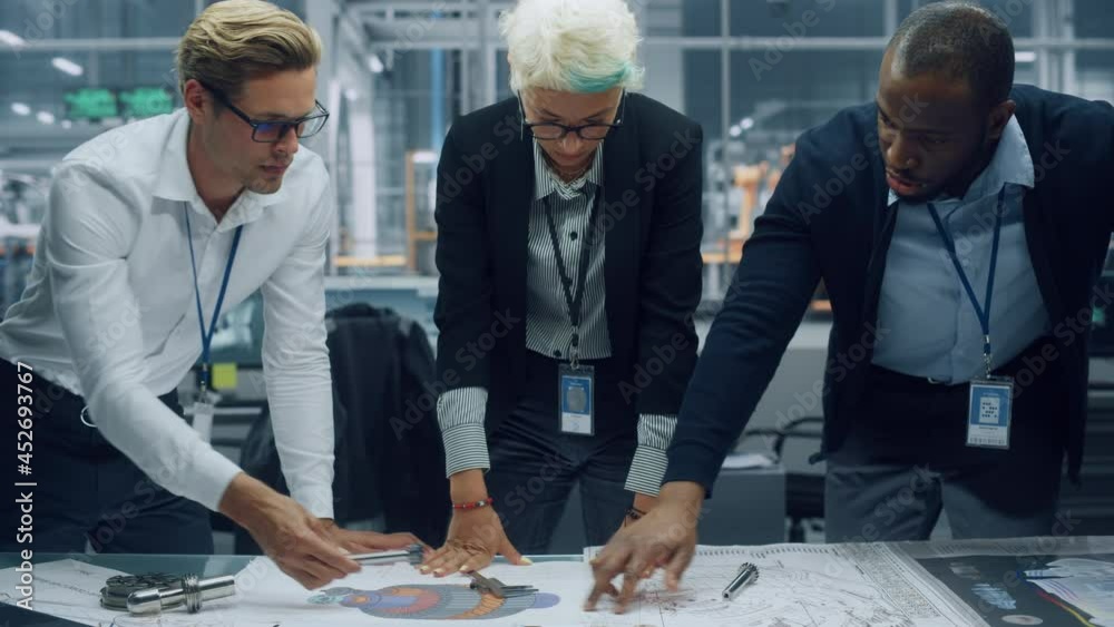 Aufkleber Young Diverse Team of Automotive Engineers Working in Office at Car Factory. Industrial Designer Talks About Electric Engine Parts with Colleagues, Discussing Technical Blueprint for Mobility Project.