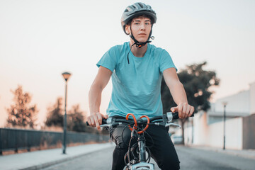 Adolescente de ruta haciendo ciclismo en la carretera de la ciudad junto a la puesta de sol