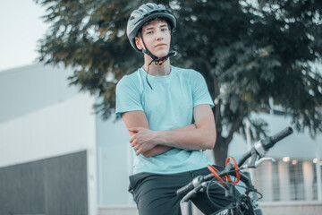 Muchacho joven adolescente con casco de protección en la carretera montado en bicicleta sentado...