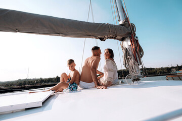 happy family mom dad son sailing on a yacht on a joint weekend. sea vacation.