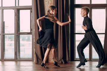 Young couple boy and girl dancing in ballroom dance Samba.