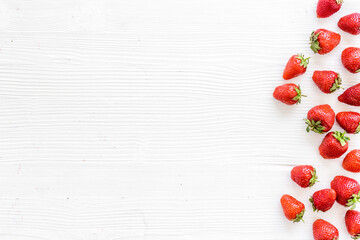 Flat lay of ripe strawberries with green leaves