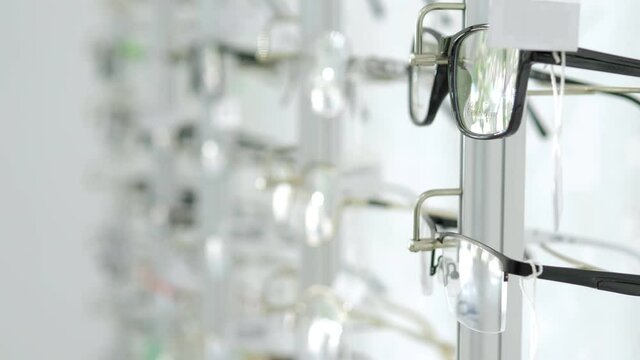 An optics store with many different glasses. Glasses are on the shelves for sale