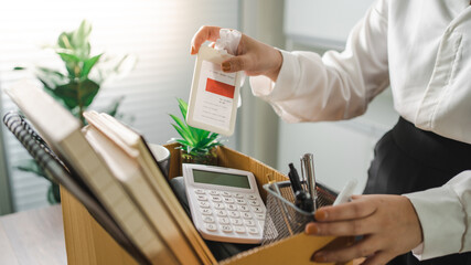 Business woman sending resignation letter and packing Stuff Resign Depress or carrying business cardboard box by desk in office. Change of job or fired from company