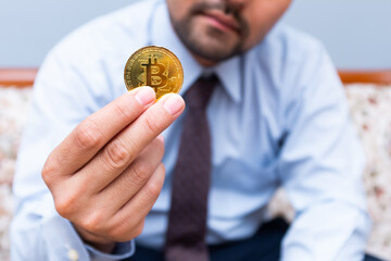 Unrecognized man holding bitcoin in hand. Investment and cryptocurrency concept.