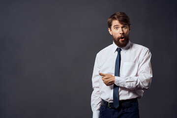 The man in a suit in a white shirt pulls the tie dark background