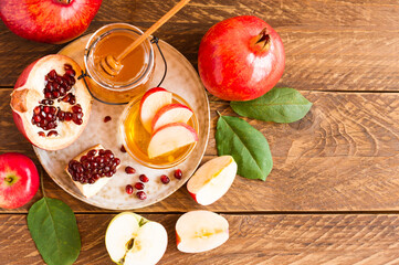 Rosh hashanah jewish new year holiday celebration concept. Honey, pomegranate and apples over wooden background. Top view