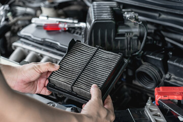 Hand a man holding new air filter part of car engine change and check of car in the engine room basic car service concept