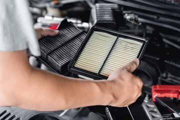 Home service car concept : A man replace the old engine air filter compared to the new one in...