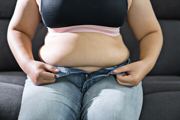 Fat woman touching his fat belly  on the sides of her stomach with her hand. fat Shape Diet...