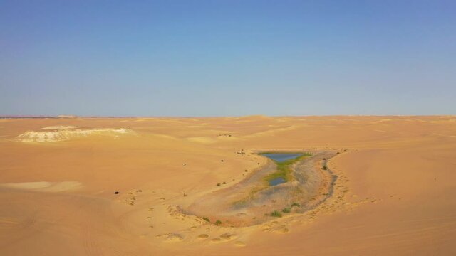 Aerial Forward Shot Of Cars Moving On Sand In Desert, Drone Flying Over Siwa Lake On Sunny Day - Siwa Oasis, Egypt