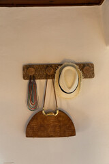 Detail of a bag and a hat hanging on the wall.