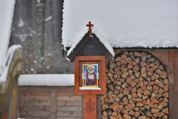 a wooden church in the forest, covered with snow in winter 