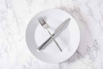 concept of intermittent fasting and ketogenic diet, weight loss. fork and knife crossed on a plate