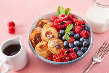 mini pancake breakfast bowl with berries and maple syrup