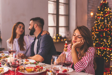 Lonely woman spending Christmas eve with friends