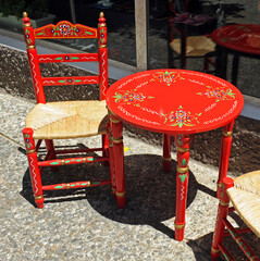 Silla y mesa andaluza tradicional pintada de rojo y decorada con flores. Mobiliario tradicional de...