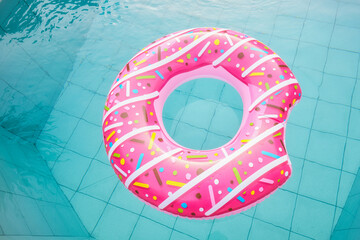 Donut pool float, ring floating in a refreshing blue swimming pool