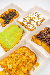 Sliced bread topping with chocolate, icing and hunny, green custard coconut jam and cereal