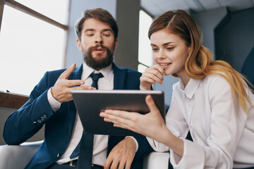 business man and woman looking at the tablet officials teamwork