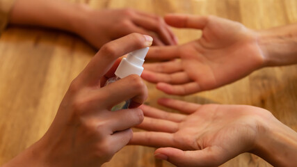 Hand triggering a sanitizing bottle at COVID-19