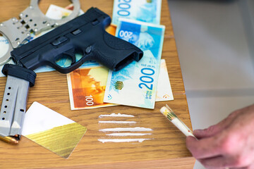 Pistol gun, bullets on background of Israeli New Shekel banknotes. mafia and criminal life. Cocaine...