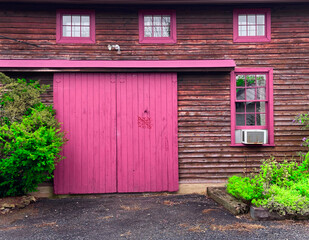 Exterior of an old building with pink doors and window frames