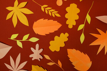 autumn paper leaves on red background, falling orange and yellow leaves wall