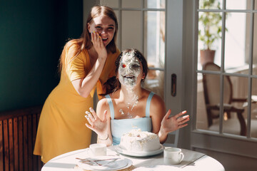 Obraz na płótnie Canvas Young woman dips face in white cake with cream. Happy fun birthday concept