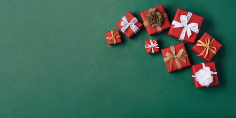 Gift boxes with white and brown bows on a green backdrop.