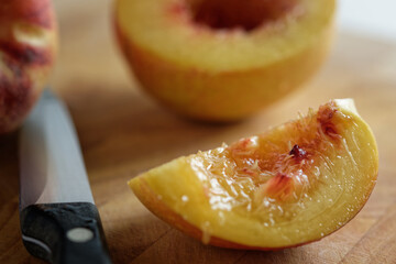 Halved nectarine on wooden cutting board.