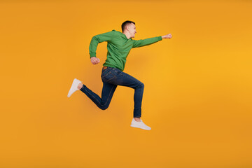 Fototapeta premium Profile portrait of hero reliable excited guy jump run raise hand hurry look empty blank space on yellow background