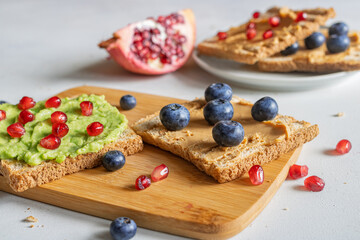 A healthy snack. Preparing breakfast. Toast with peanut butter and blueberries. Sandwiches with avocado and pomegranate seeds. Healthy Eating. Healthy lifestyle. Dietetics.